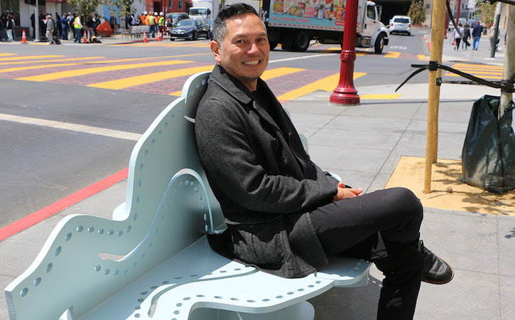 Professor Arcega sitting on a bench smiling 