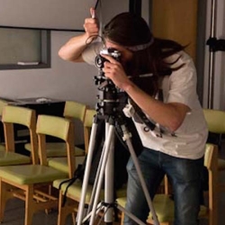 Student looking through photographic camera on a tripod