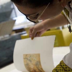 Student looking at new print created in class